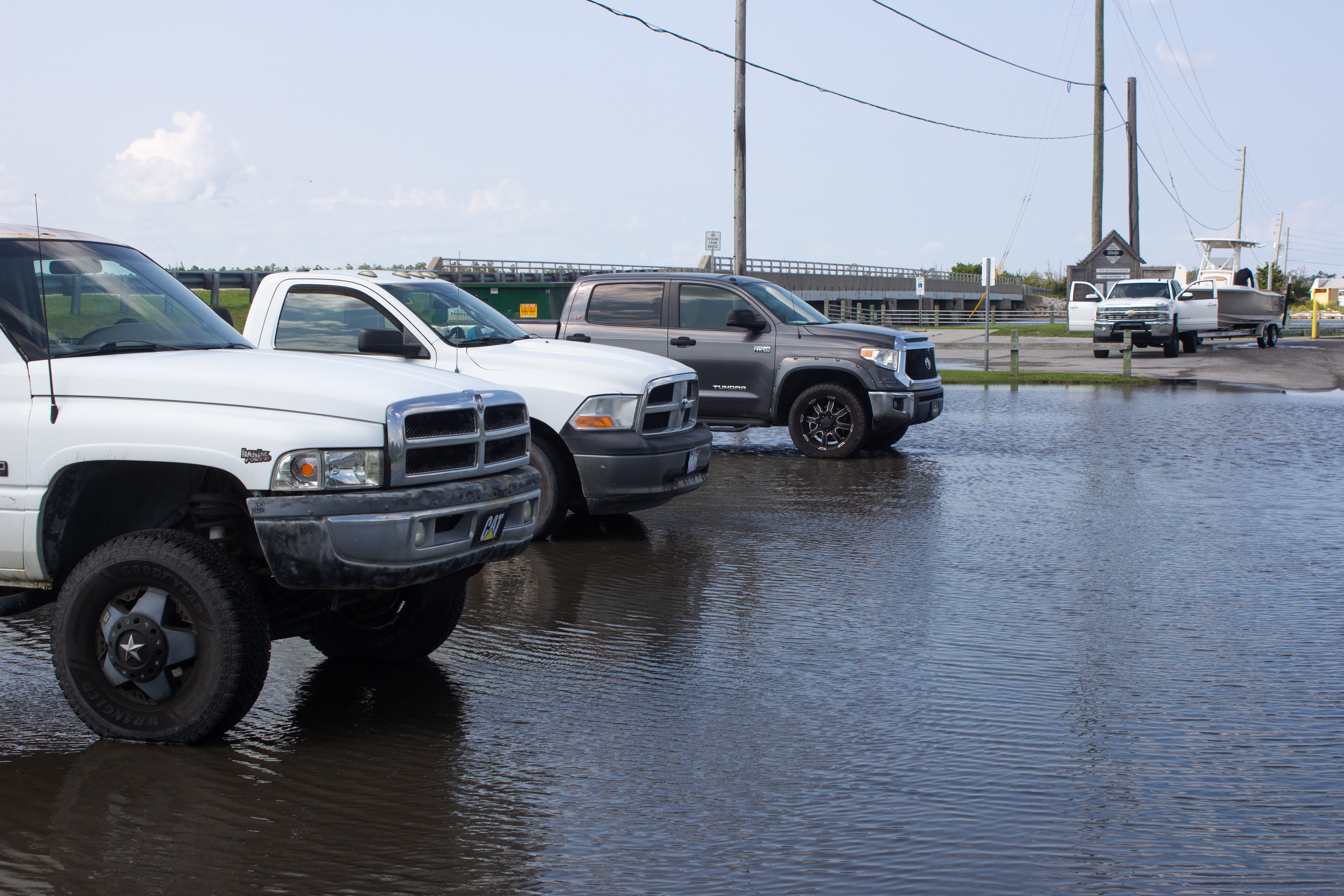 A set of pickup trucks parked in shallow water at a public boat launch near Davis, NC.